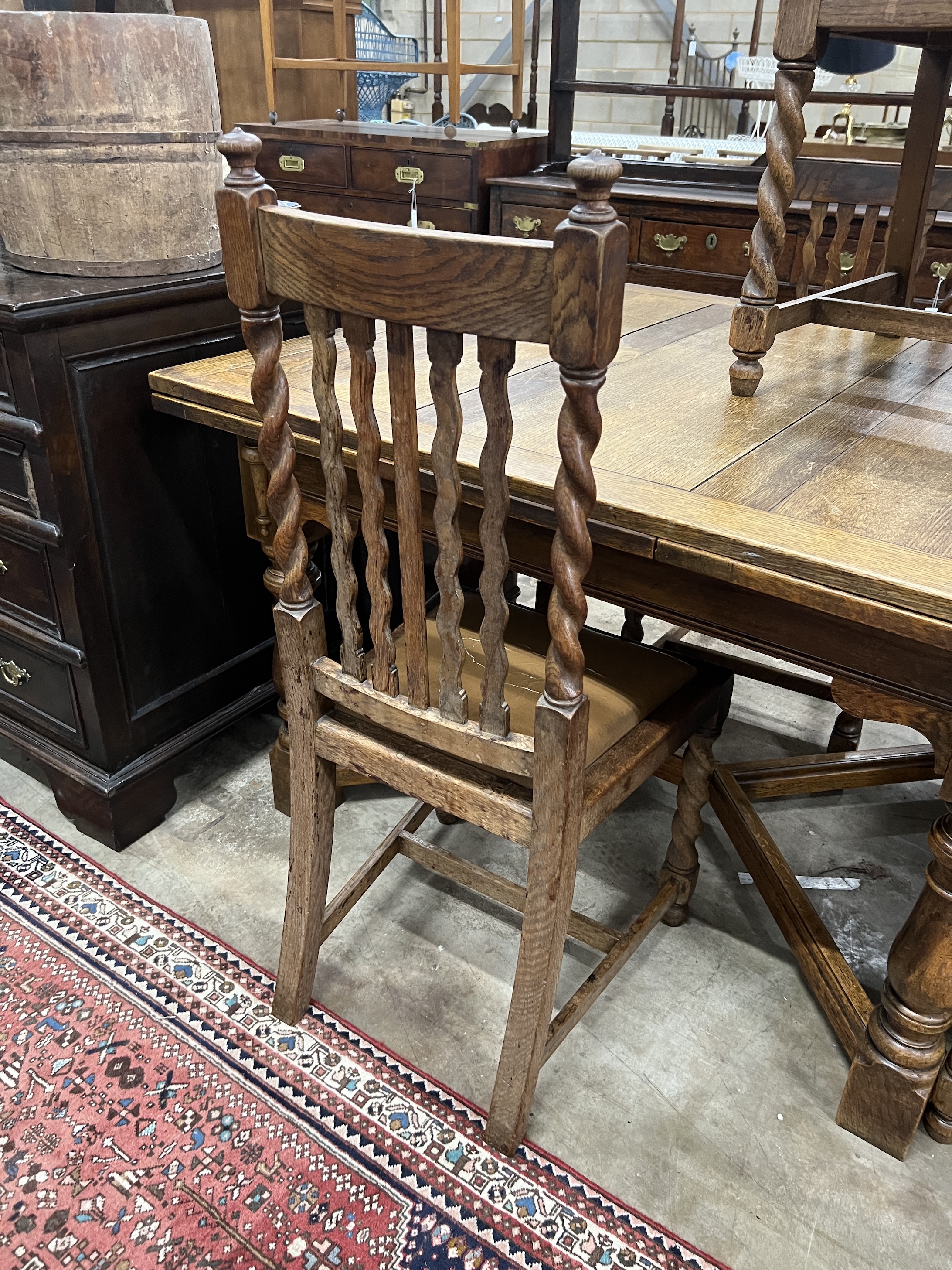 An early 20th century oak draw leaf dining table, width 120cm, depth 106cm, height 76cm together with five oak dining chairs, one with arms